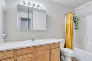 Full bathroom featuring shower / tub combo with curtain, vanity, and toilet