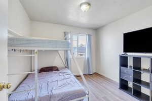 Bedroom featuring a textured ceiling, wood finished floors, and baseboards