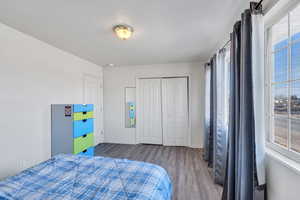 Bedroom with a closet, baseboards, and wood finished floors