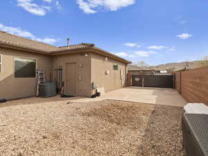 Rear view of property with a patio area, central AC unit, stucco siding, and fence