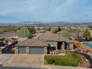 View of front of property featuring a tile roof, fence, stone siding, and stucco siding