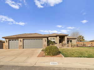 View of front of house with fence, a tiled roof, stucco siding, driveway, and an attached garage