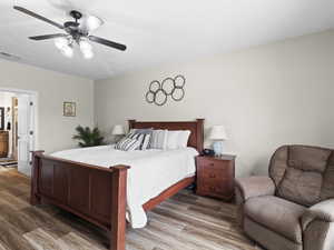 Bedroom featuring ceiling fan, visible vents, and light wood-style flooring