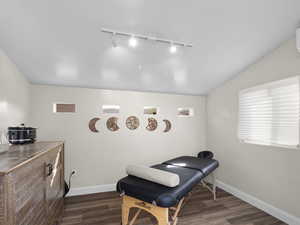 Living area with lofted ceiling, wood finished floors, and baseboards