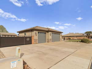 Exterior space with fence, driveway, stucco siding, stone siding, and a tiled roof