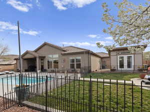 Back of house with fence, a tiled roof, stucco siding, french doors, and a patio