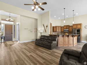 Living area featuring recessed lighting, light wood-type flooring, a ceiling fan, and a chandelier