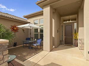 Property entrance featuring a patio area, stucco siding, and a tiled roof