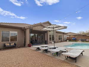 Back of house with a patio, fence, a fenced in pool, stucco siding, and a tiled roof