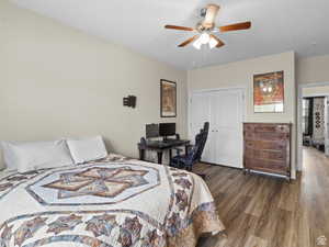 Bedroom with wood finished floors, a closet, and a ceiling fan