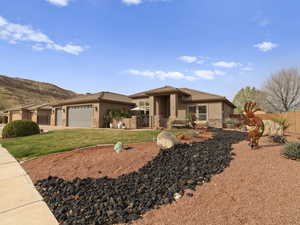 Prairie-style home with stucco siding, stone siding, fence, and a tiled roof