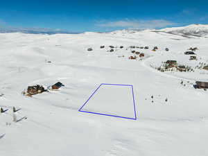 Snowy aerial view featuring a mountain view and snow covered Soldier Creek Bay to the back left.