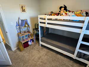 Carpeted bedroom featuring baseboards and a textured ceiling