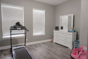 Workout room with light wood finished floors and baseboards