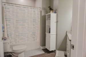 Bathroom with vanity, shower / bath combination with curtain, and toilet