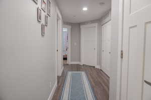 Corridor featuring wood finished floors, visible vents, and baseboards