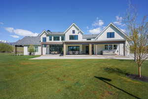 Back of house with a patio area and a lawn