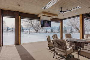 Snow covered patio featuring a ceiling fan and outdoor dining space