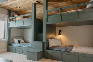 Unfurnished bedroom with wooden ceiling and carpet