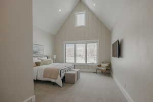 Bedroom featuring high vaulted ceiling, light colored carpet, multiple windows, and baseboards