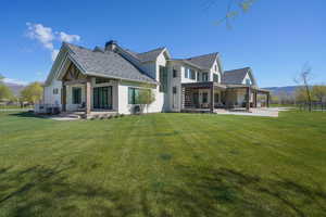 Rear view of property with a yard, a patio area, a mountain view, and fence