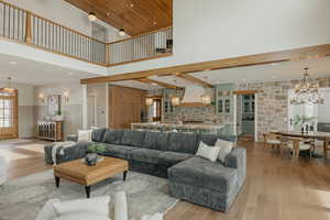 Living room featuring a wainscoted wall, recessed lighting, a notable chandelier, and light wood-style floors