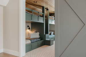 Carpeted bedroom with wooden ceiling and recessed lighting