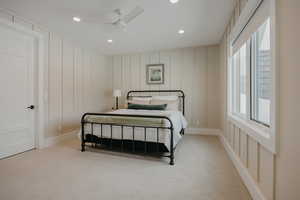 Bedroom featuring light carpet, ceiling fan, a decorative wall, and recessed lighting