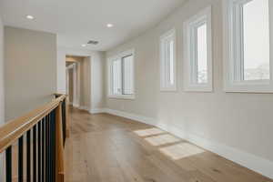 Spare room with recessed lighting, plenty of natural light, visible vents, and light wood-style floors