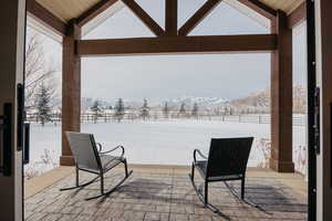 Snow covered patio featuring a mountain view