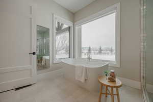 Full bath with a freestanding tub, baseboards, visible vents, and tile patterned floors