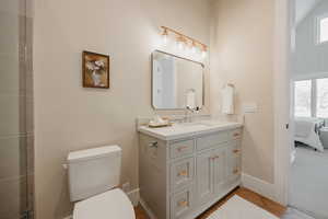 Bathroom with toilet, vanity, ensuite bath, baseboards, and tile patterned floors