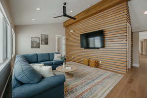 Living area with recessed lighting, ceiling fan, vaulted ceiling, light wood-type flooring, and baseboards