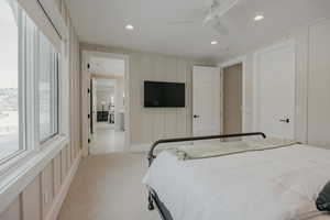 Bedroom featuring a ceiling fan, recessed lighting, light carpet, and a decorative wall