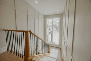 Stairs with baseboards, a decorative wall, and recessed lighting