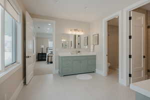 Full bathroom with recessed lighting, vanity, toilet, and baseboards