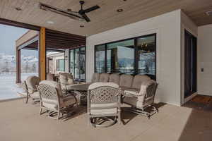 Snow covered patio with ceiling fan, visible vents, a mountain view, and an outdoor living space