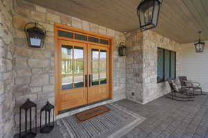 View of exterior entry with stone siding and french doors