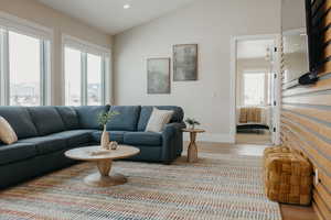 Living room with recessed lighting, vaulted ceiling, baseboards, and wood finished floors