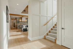 Staircase with recessed lighting, a decorative wall, brick wall, and wood finished floors