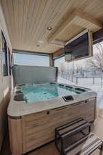 Exterior space with wood ceiling and a hot tub