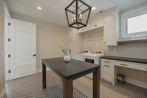 Interior space featuring cabinet space, baseboards, visible vents, washer and clothes dryer, and recessed lighting