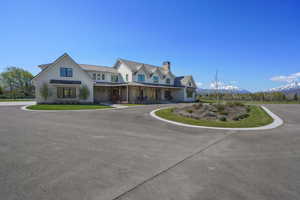 View of front facade with a porch, fence, a mountain view, a chimney, and a standing seam roof