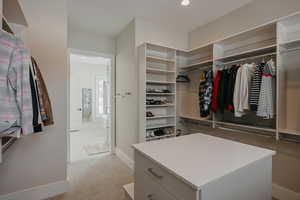 Spacious closet featuring light colored carpet