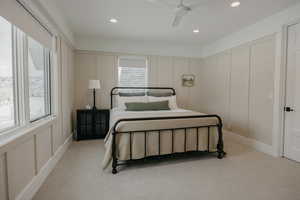 Bedroom with light carpet, a decorative wall, a ceiling fan, and recessed lighting