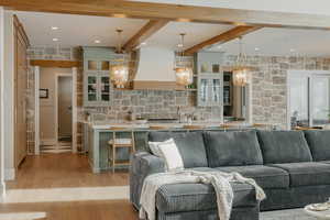 Living area with light wood-style floors and beamed ceiling