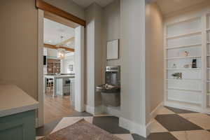 Hallway with built in features, recessed lighting, a chandelier, and baseboards