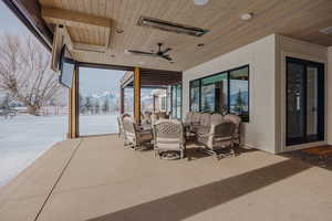 Snow covered patio with an outdoor living space and a ceiling fan