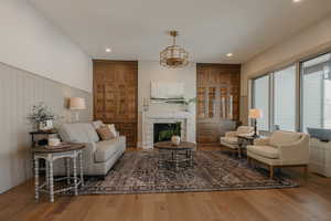 Living room with a fireplace, wood finished floors, and recessed lighting