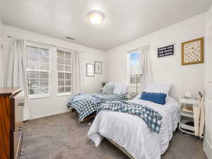 Carpeted bedroom featuring an extra window due to being an end unit